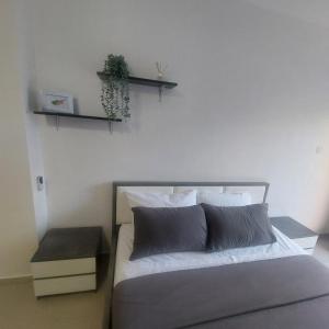 a bedroom with a bed and a shelf on the wall at Modern Studio apartment Armonia Court in Paralimni