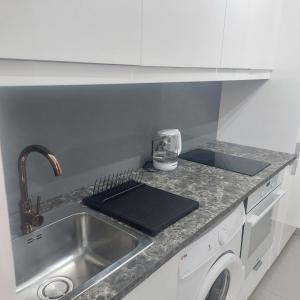 a kitchen with a sink and a washing machine at Modern Studio apartment Armonia Court in Paralimni