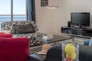 a living room with a couch and a tv at Calheta Victory View by An Island Apart in Calheta