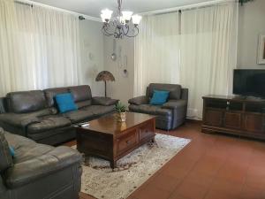 a living room with two couches and a coffee table at Micasa Sucasa Guesthouse in Lephalale