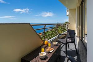 a balcony with a table and chairs with a view of the ocean at Calheta Victory View by An Island Apart in Calheta