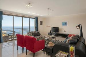 a living room with a view of the ocean at Calheta Victory View by An Island Apart in Calheta