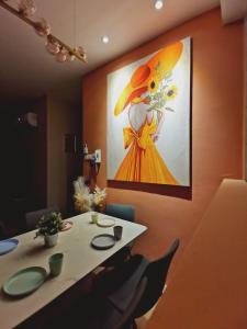 a painting of a woman in a yellow dress on a wall at Stylish Micasa 4 Home 3BR+FREE PARKING -Hann's Residence in Sibu