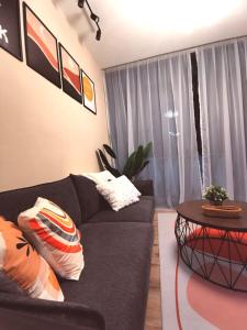 a living room with a black couch and a table at Stylish Micasa 4 Home 3BR+FREE PARKING -Hann's Residence in Sibu