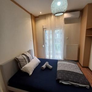 Un dormitorio con una cama azul con dos zapatos. en Ifestionos 2-Bedroom Apartment, en Tesalónica