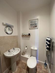 a bathroom with a white toilet and a sink at Masons Arms Amble in Amble