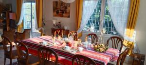 a dining room table with a red and white table cloth at Chambre d'Hôte Villa Maritampona in Antsirabe