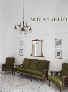 un soggiorno con 2 divani verdi e uno specchio di Charming Trulli ad Alberobello