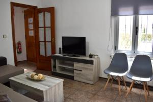 Una sala de estar con dos sillas y un televisor de pantalla plana. en Alma del Tajo VUT, en Villamanrique de Tajo