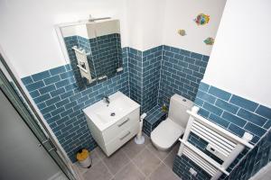 ein blau gefliestes Badezimmer mit Toilette und Waschbecken in der Unterkunft Romantic sea view studio, steps away from the beach in Antibes