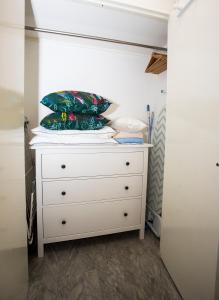 eine weiße Kommode mit zwei Kissen darüber in der Unterkunft Romantic sea view studio, steps away from the beach in Antibes