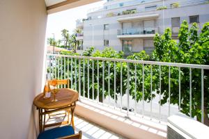 ein Balkon mit Tisch und Stühlen und ein Gebäude in der Unterkunft Romantic sea view studio, steps away from the beach in Antibes