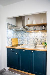 eine Küche mit blauen Schränken und einer Spüle in der Unterkunft Romantic sea view studio, steps away from the beach in Antibes + 8 Fotos