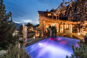 ein Haus mit einem Pool vor einem Haus in der Unterkunft Naturhotel Lüsnerhof in Lüsen