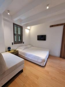 2 Betten in einem Zimmer mit einem Sofa und einem TV in der Unterkunft Beautiful Villa with Garden Princess Islands in Istanbul