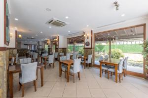 a restaurant with wooden tables and white chairs at Olinda Hotel & Spa in Şile