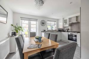 a kitchen and dining room with a wooden table and chairs at Stylish 3-Bed House in Langley, Driveway Parking! in Langley Marish