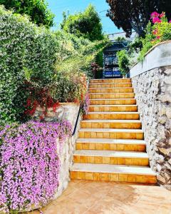 een trap met bloemen en een stenen muur bij B&B L'Agapanto in Capri