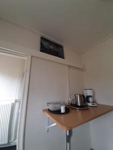 a kitchen with a table with a tv on the wall at Klein Eikelenkamp in Wilp