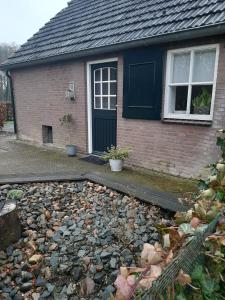 una casa con una gran pila de rocas delante de ella en Klein Eikelenkamp en Wilp