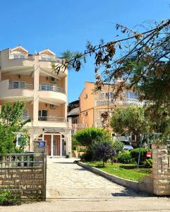 a building with a gate in front of a street at Open Sea Apartmani in Grebaštica