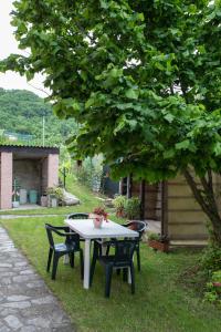 a table and chairs under a tree in a yard at La collina dei nonni - Tarzo in Tarzo