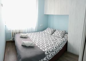 Un dormitorio con una cama con sábanas y almohadas blancas y negras. en Apartament Queen, en Malbork