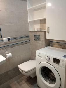 uma casa de banho com uma máquina de lavar roupa e um WC em Apartament Queen em Malbork