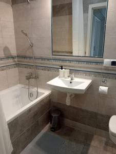 a bathroom with a sink and a bath tub and a shower at Apartament Queen in Malbork