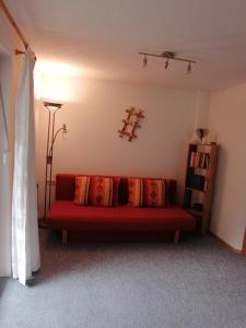 a living room with a red couch with pillows at Ferienwohnung Pohl in Bach