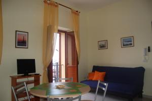 sala de estar con sofá azul y mesa en Le Casette del Porto di Sciacca, en Sciacca