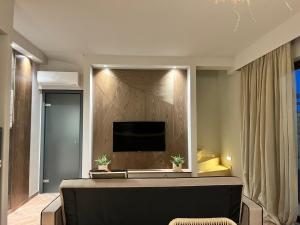 a living room with a tv on a wall at Al Mare Villas in Kiotari