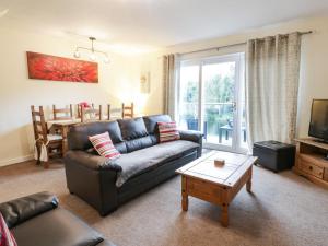 ein Wohnzimmer mit Sofa und Tisch in der Unterkunft Barley Cottage in Newton Stewart