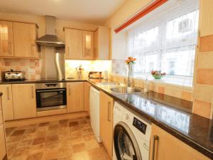 a kitchen with a sink and a dishwasher at Barley Cottage in Newton Stewart