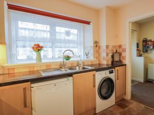 eine Küche mit Spüle und Waschmaschine in der Unterkunft Barley Cottage in Newton Stewart + 15 Fotos
