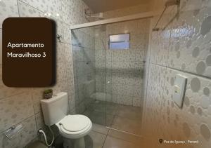 La salle de bains est pourvue d'une douche et de toilettes blanches. dans l'établissement APARTAMENTO MARAVILHOSO 3, à Foz do Iguaçu