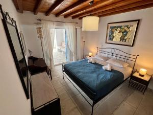 a bedroom with a bed with a blue comforter at Cycladic style Maisonette with staggering sea view in Agios Sostis Mykonos
