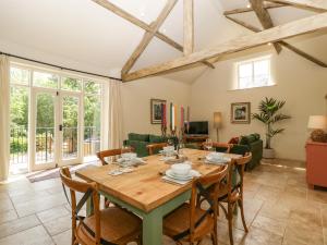a living room with a wooden table and chairs at The Hayloft in Honiton