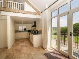 a kitchen with a large glass door leading to a balcony at The Hayloft in Honiton
