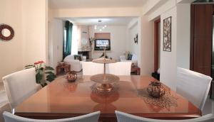 a dining room with a wooden table and white chairs at Chrysanthi's House in Áyios Kírikos