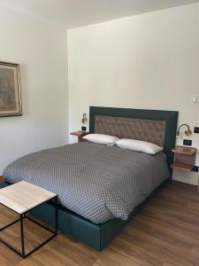 1 cama con 2 almohadas y 1 mesa en el dormitorio en VILLA MARGHERITA, en Pieve di Soligo