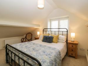 a bedroom with a bed and two lamps and a window at The Hayloft in Honiton