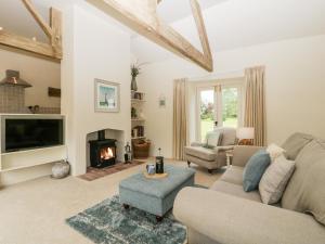 a living room with a couch and a fireplace at The Shippon in Honiton