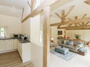 a kitchen and living room with wooden beams at The Shippon in Honiton
