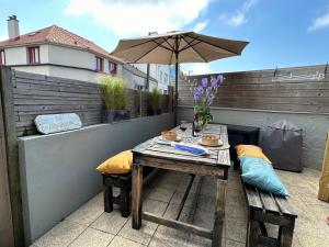 a table on a balcony with an umbrella at Rev d’Opale in Wimereux