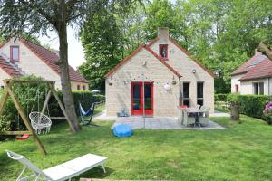 a house with a playground in the yard at 7 person House with swing, firepit, hammock, garden, swimming lake, child friendly, in- and outside playground, and great coffee in Ewijk