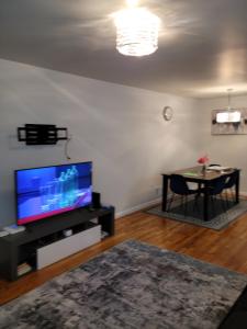 a living room with a flat screen tv and a table at Daphy Ruby Stays in Newark