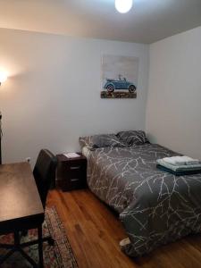 a bedroom with a bed with a car picture on the wall at Daphy Ruby Stays in Newark