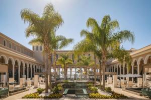 a courtyard with palm trees in a building at Red Level at Gran Melia Palacio de Isora - Adults Only in Alcalá