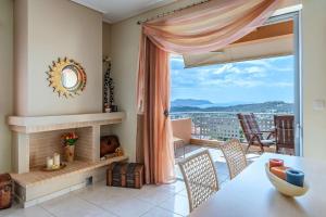sala de estar con chimenea, mesa y sillas en 2 Bedroom Cozy apartment with Sea View and balcony, en Anavyssos